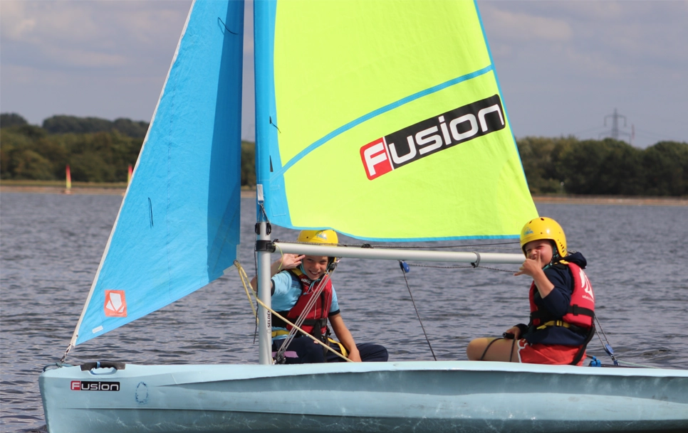 Two youths sailing on the water.